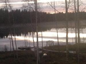 a lake with a boat in the middle of it at Villa Somosenranta in Oikarainen