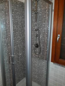 y baño con ducha y puerta de cristal. en B&B Il Brigante, en Alghero