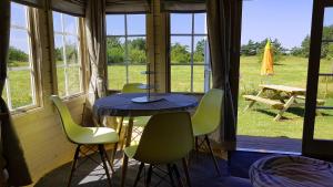 Habitación con mesa, sillas, mesa y ventanas. en Camping Rugumi, en Saraiķi
