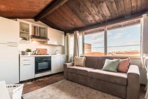 un soggiorno con divano e una grande finestra di Design Apartments Sassari-Skyline a Sassari