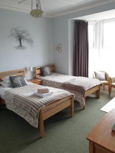 a bedroom with two beds and a desk at Malin House Hotel in Saundersfoot