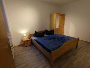 クックスハーフェンにあるHaus Alt-Doseのベッドルーム1室(木製ベッド1台、青い毛布付)