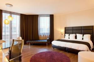 um quarto de hotel com uma cama grande e uma mesa em Holiday Inn Genoa City by IHG em Génova