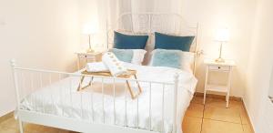 a bedroom with a white bed with blue pillows at Bright Renovated Room Close to Everything in Jerusalem