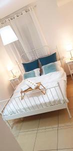 een slaapkamer met een wit bed met blauwe kussens bij Bright Renovated Room Close to Everything in Jeruzalem
