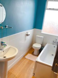 a bathroom with a toilet and a sink and a tub at Lovely 3 beds house 6 guests King beds in Sheffield
