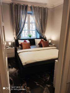 Schlafzimmer mit einem Bett vor einem Fenster in der Unterkunft Apartament Nina in Warschau