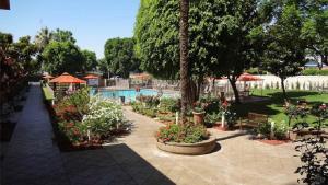 um jardim com flores e uma piscina em Ontario Airport Hotel & Conference Center em Ontario