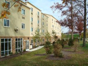 a large building with trees in front of it at Candlewood Suites Pittsburgh-Cranberry, an IHG Hotel in Cranberry Township