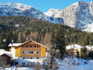 een gebouw in de sneeuw naast een berg bij Ciasa Andy in Badia