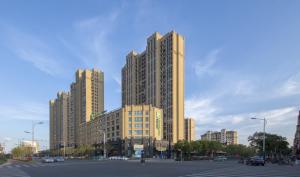 duży budynek w mieście z parkingiem w obiekcie Holiday Inn Express Zhangjiagang East, an IHG Hotel w mieście Zhangjiagang