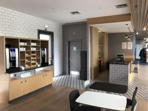 a room with a kitchen with a table and chairs at Holiday Inn Express Porto Exponor, an IHG Hotel in Leça da Palmeira