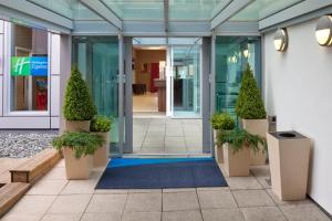 une entrée de bureau avec des plantes en pot et un tapis bleu dans l'établissement Holiday Inn Express Hull City Centre, an IHG Hotel, à Hull