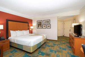 a hotel room with a bed and a flat screen tv at La Quinta by Wyndham Denver Southwest Lakewood in Lakewood