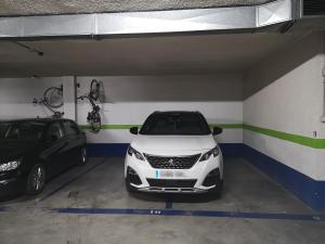 a white car parked in a garage with two bikes at Spectacular views. All new with free parking in Córdoba