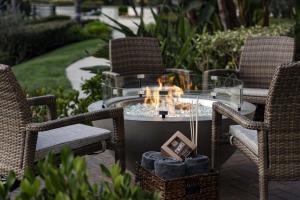 eine Terrasse mit einem Tisch, Stühlen und einer Feuerstelle in der Unterkunft Hyatt Regency Huntington Beach Resort and Spa in Huntington Beach