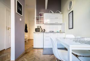 ワルシャワにあるElegant Apartment Copernicusの白いキッチン(白いテーブルと椅子付)