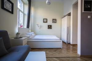 ワルシャワにあるElegant Apartment Copernicusのベッドルーム1室(ベッド1台、ソファ、窓付)