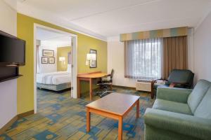 a hotel room with a couch and a bed and a living room at La Quinta Inn and Suites by Wyndham, Ocala in Ocala