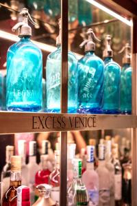 
a glass shelf filled with bottles of alcohol at Excess Venice Boutique Hotel & Private Spa - Adults Only in Venice
