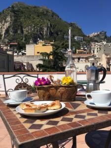 un tavolo con un piatto di cibo su un tavolo con vista di B&B Porta del Re a Taormina