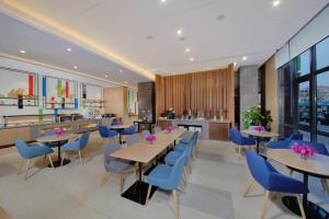 une salle à manger avec des tables et des chaises bleues dans l'établissement Holiday Inn Express Zhangjiagang East, an IHG Hotel, à Zhangjiagang