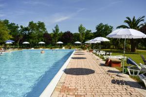 a swimming pool with chairs and umbrellas at Centro Vacanze - Garden River in Altidona