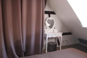 a bedroom with a sink and a mirror on a table at Appartement les Violettes in Colmar