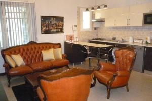 a kitchen with leather chairs and a couch and a table at SuperF2+2020 in LʼAgha