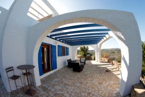 un edificio azul y blanco con un arco en Villa Teresa, en Agua Amarga