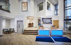 an office lobby with a staircase and windows at Holiday Inn Express Windsor Waterfront, an IHG Hotel in Windsor