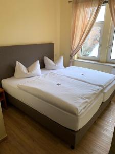 ein großes Bett in einem Schlafzimmer mit Fenster in der Unterkunft Hotel Thüringer Hof in Jena