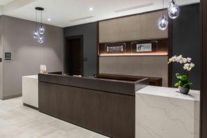 a hotel lobby with a reception desk and pendant lights at Holiday Inn Express - Boston South - Quincy, an IHG Hotel in Quincy