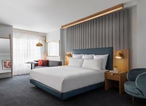 a hotel room with a large bed and a chair at 21c Museum Hotel Chicago in Chicago