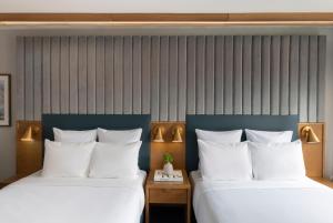 two beds in a hotel room with white pillows at 21c Museum Hotel Chicago in Chicago