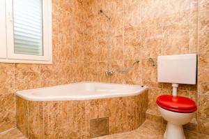 łazienka z toaletą i wanną w obiekcie Apartments Lampalo w mieście Okuklje +37 zdjęć
