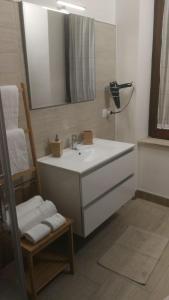 een badkamer met een wastafel, een spiegel en een stoel bij B&B Solferino in Telese