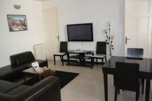 ein Wohnzimmer mit schwarzen Möbeln und einem Flachbild-TV in der Unterkunft ApartF32020 in El Biar