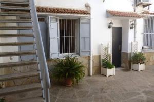een wit huis met een trap en potplanten bij ApartF32020 in El Biar