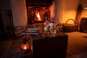una bottiglia di alcol su un tavolo in una stanza con un camino di Thistle Thatch Cottage and Hot Tub - Mourne Mountains a Newcastle