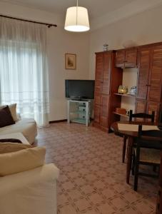 a living room with a couch and a television at La casa di GB in Pieve di Teco