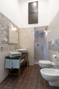 a bathroom with two sinks and a toilet and a shower at Casa Rebecca in Brindisi
