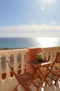 un tavolo e sedie su un balcone con vista sull'oceano di APARTAMENTO ANA a Costa Calma