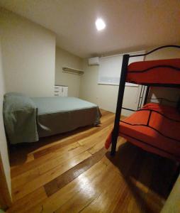 1 dormitorio con litera y suelo de madera en Dptos CerBo en Deán Funes