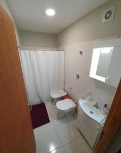 a bathroom with a toilet and a sink at Dptos CerBo in Deán Funes