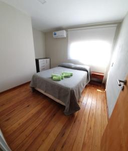 ein Schlafzimmer mit einem Bett mit grünen Kissen darauf in der Unterkunft Dptos CerBo in Deán Funes