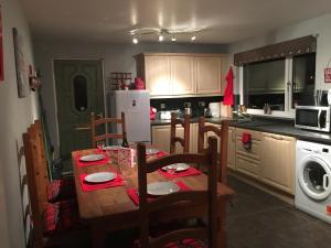 a kitchen with a wooden table with chairs and a kitchen with a sink at Unique Garden Centre Country Cottage in Fraserburgh