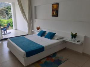 a bedroom with a large bed with blue pillows at Villa Zully in Villeta