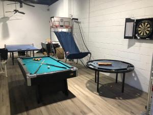 a room with a pool table and a dart board at 9BR-SLEEPS 19. Amazing Deal!! in New Orleans