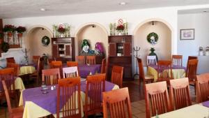 Hotel Los Arcos في ولاية دورانغو: غرفة طعام مع طاولات وكراسي أرجوانية